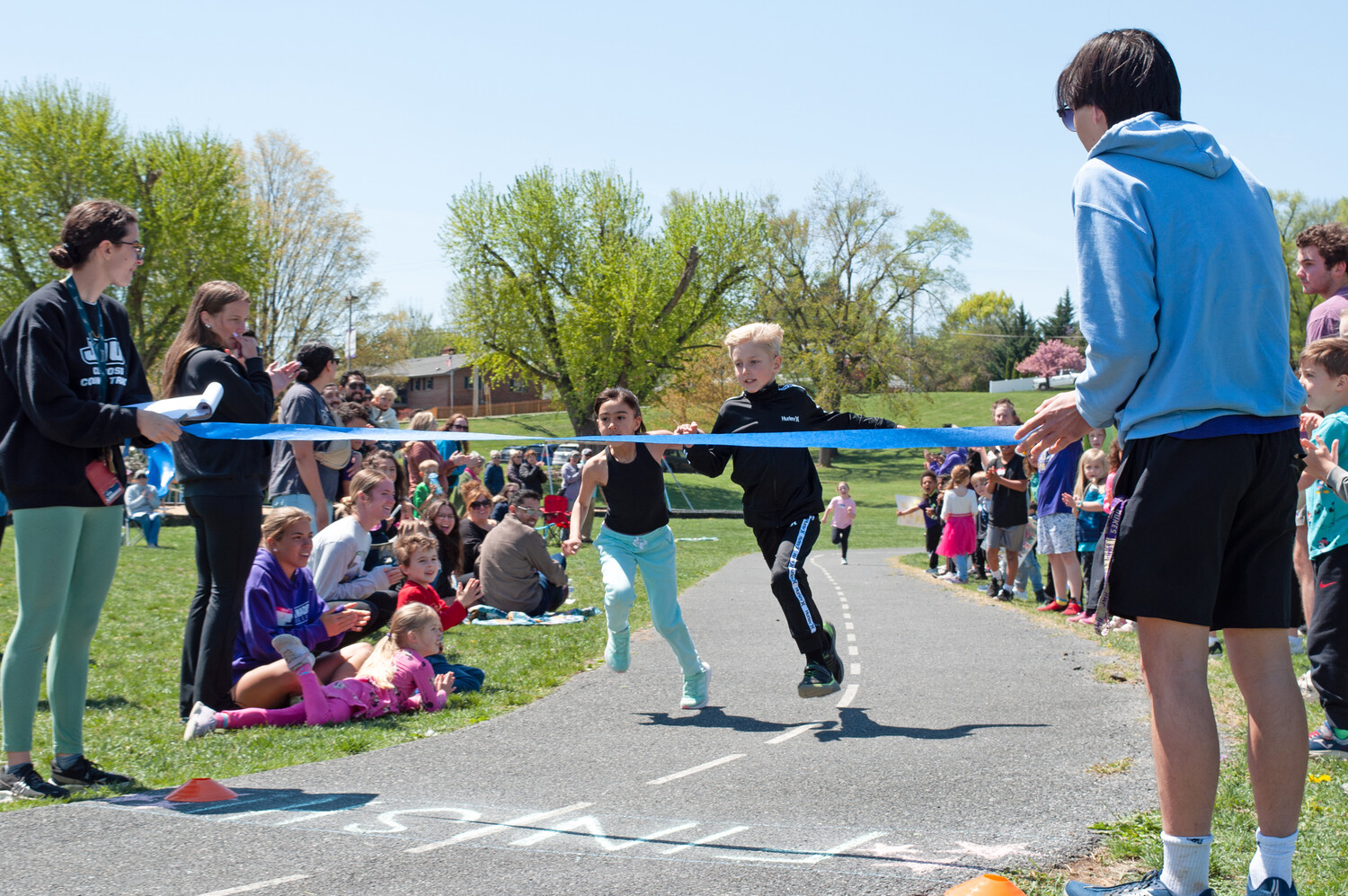 Two young runners reach the end of a race